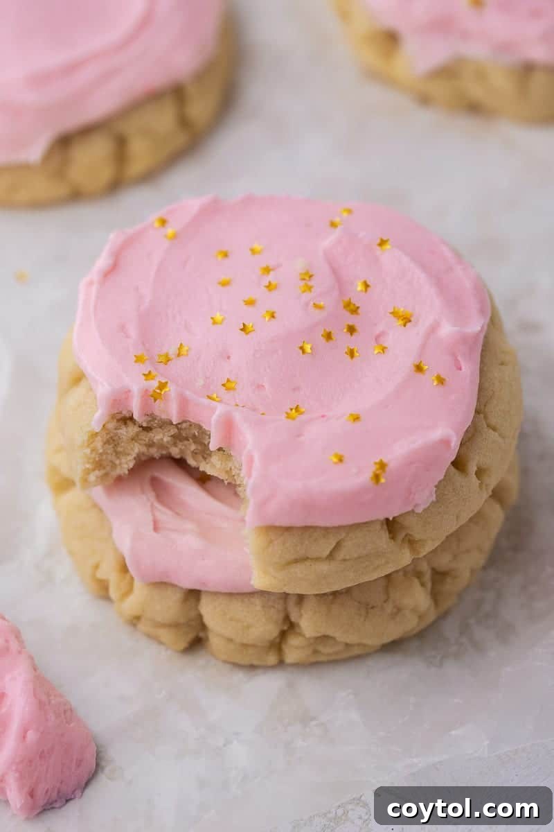 A stack of delightful Crumbl-style chilled pink sugar cookies, perfectly frosted and ready to enjoy.