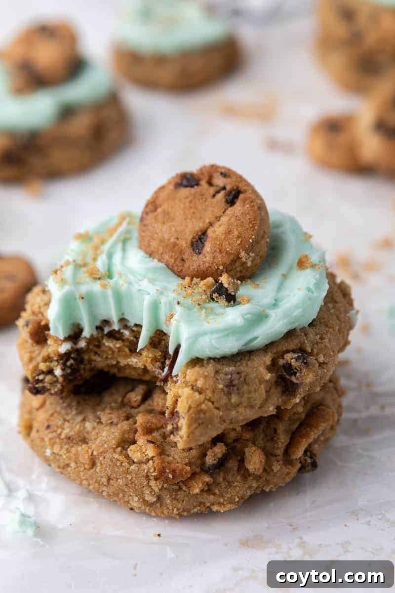 Vibrant Crumbl-style Blue Monster Cookies, loaded with mini chocolate chips and Chips Ahoy cookie crumbs, topped with light blue vanilla frosting.
