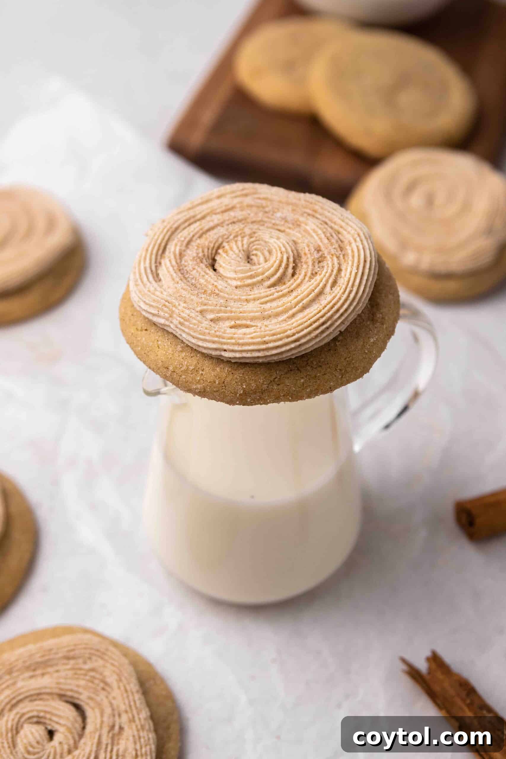 A perfectly balanced Crumbl-style churro cookie resting on a glass of milk, inviting a delightful dunk.