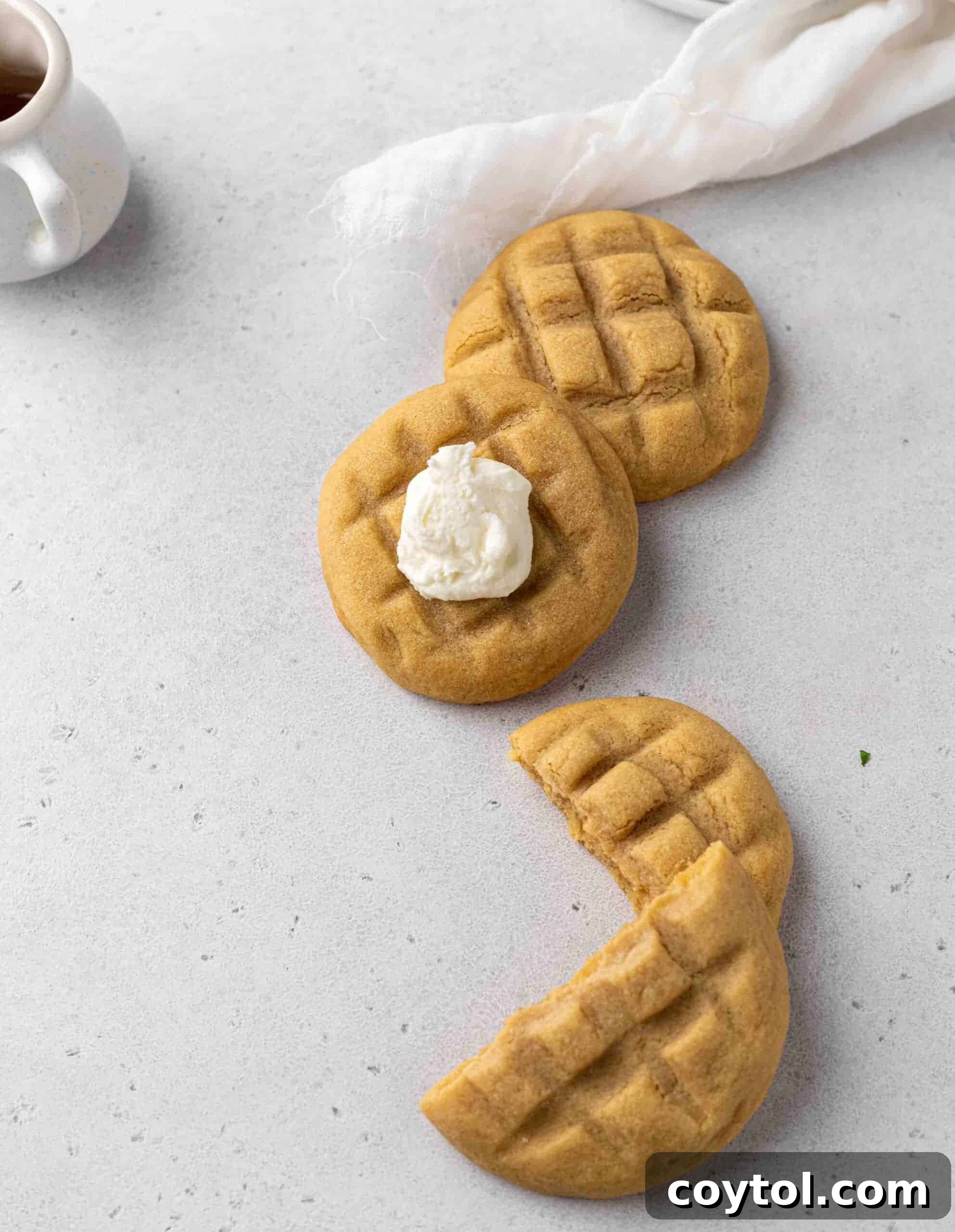 Delicious Crumbl-style waffle cookies, topped with creamy buttercream and a drizzle of syrup, evoking a cozy breakfast.
