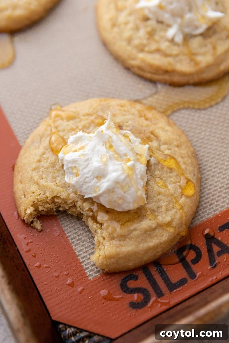Comforting Crumbl-style Cornbread Cookies, topped with sweet honey butter frosting, a Southern-inspired delight.