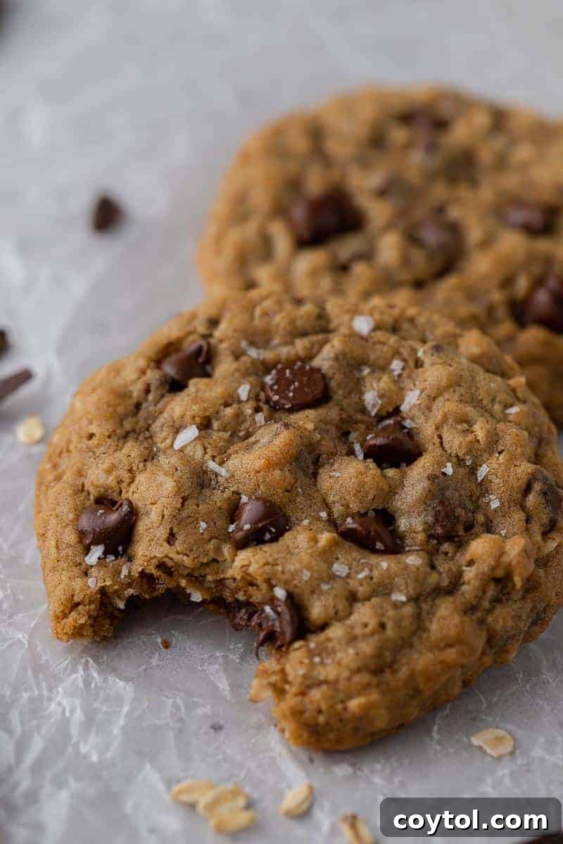 Thick and soft Crumbl-style oatmeal chocolate chip cookies, stacked and inviting.