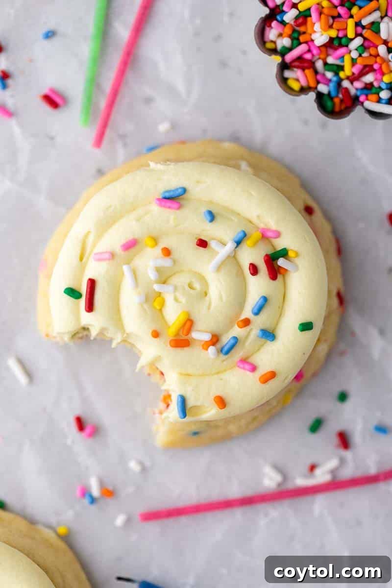 An overhead shot of festive Crumbl-style birthday cake cookies, adorned with colorful sprinkles and frosting.