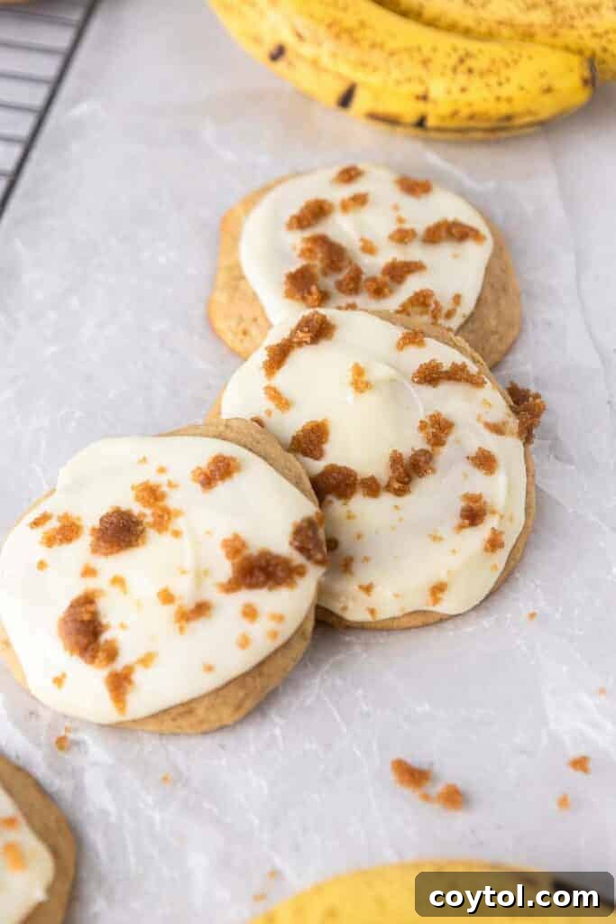 Glazed banana bread cookies topped with brown sugar crumbs on a cooling rack.