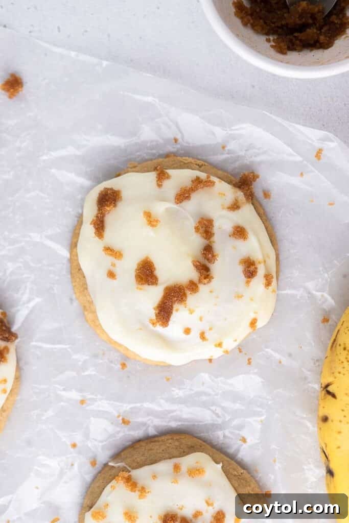 Overhead view of several Crumbl banana bread cookies, perfectly glazed and garnished.