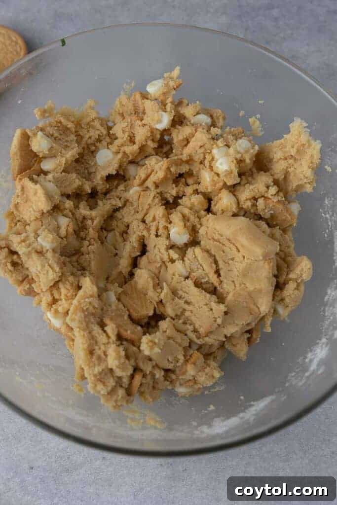 Golden Oreo cookie dough with white chocolate chips and chopped Oreos mixed in