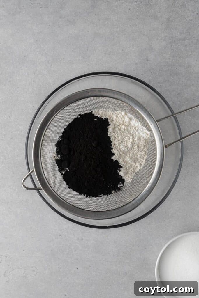 Spooky Black Velvet Monster Cupcakes 4 Sifting dry ingredients for black velvet cupcakes
