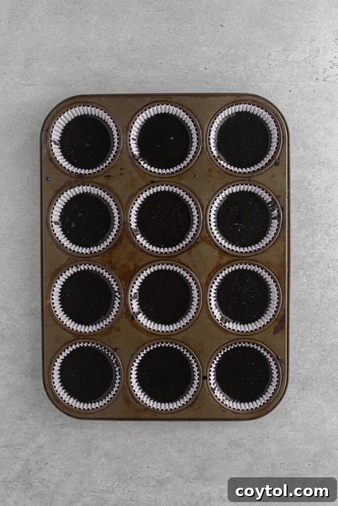 Spooky Black Velvet Monster Cupcakes 8 Black cupcakes baking in a muffin tin