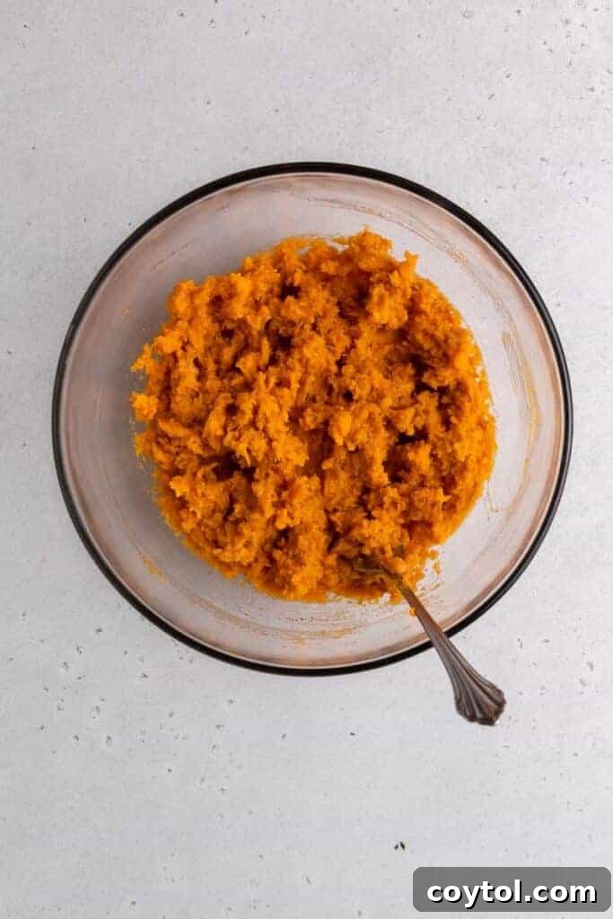 Twice-Baked Pecan Pie Sweet Potatoes 7 Mash in a bowl with butter cinnamon and maple syrup after mixing.