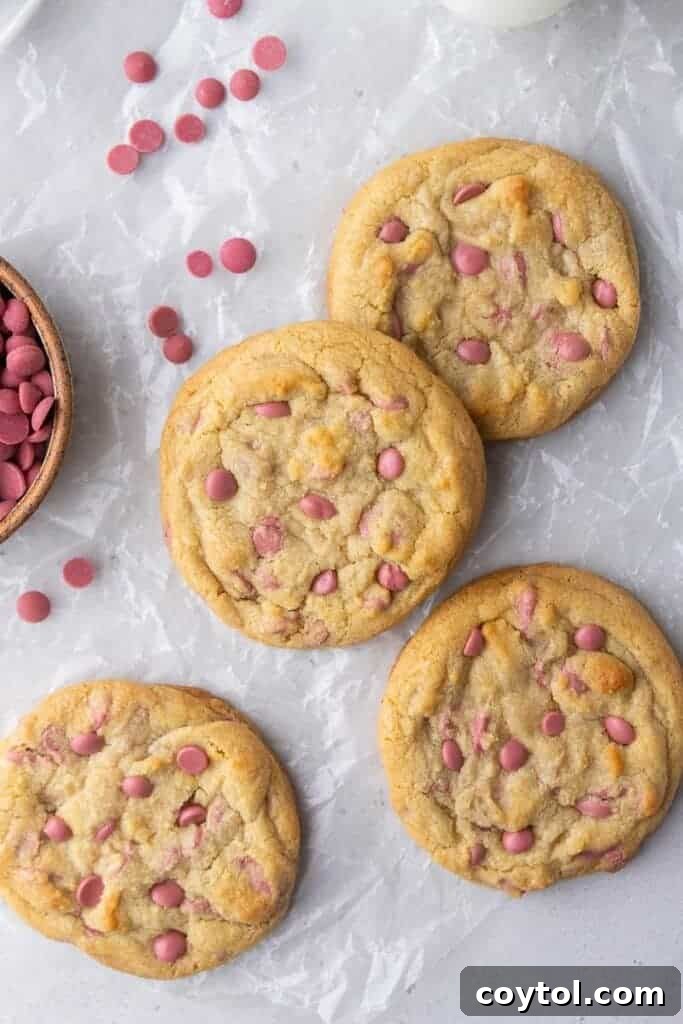 Freshly baked Crumbl ruby chocolate chip cookies on a baking sheet