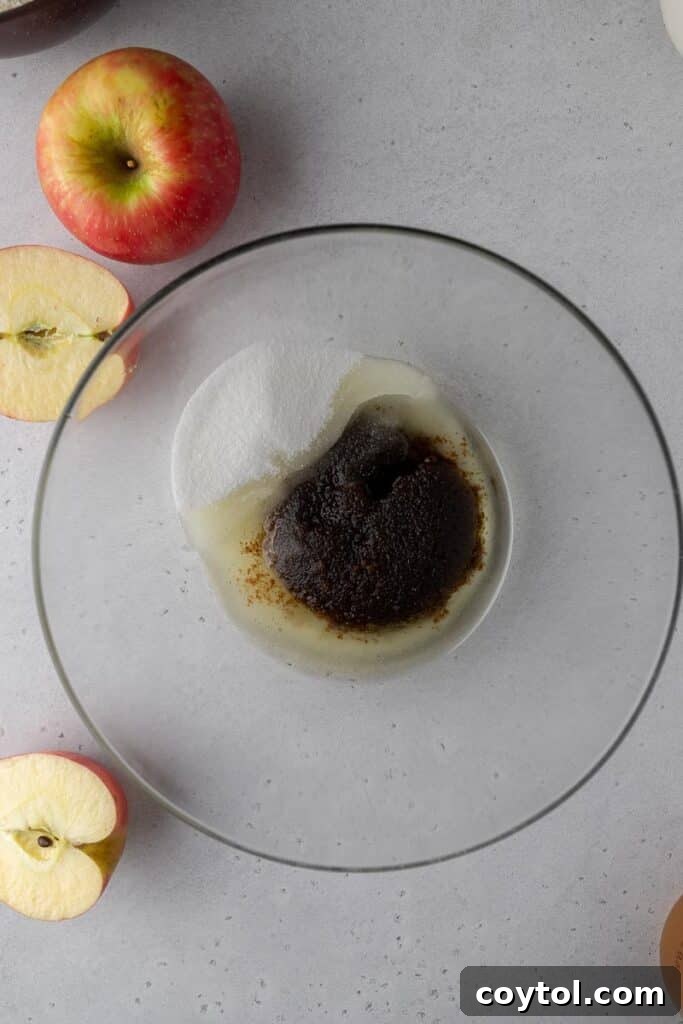 Close-up of a mixing bowl containing dark brown sugar, granulated sugar, and neutral oil, perfectly combined and ready for the next steps in preparing the bundt cake batter.