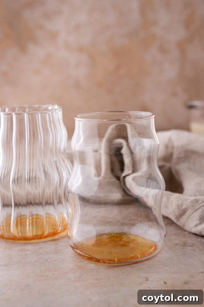 Golden Honey Oat Milk Latte: Hot or Iced 4 Clear glass with honey at the bottom, the first step in making a honey oat milk latte.