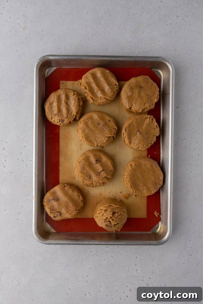 Scooped and flattened peanut butter cookie dough discs ready for chilling and baking.
