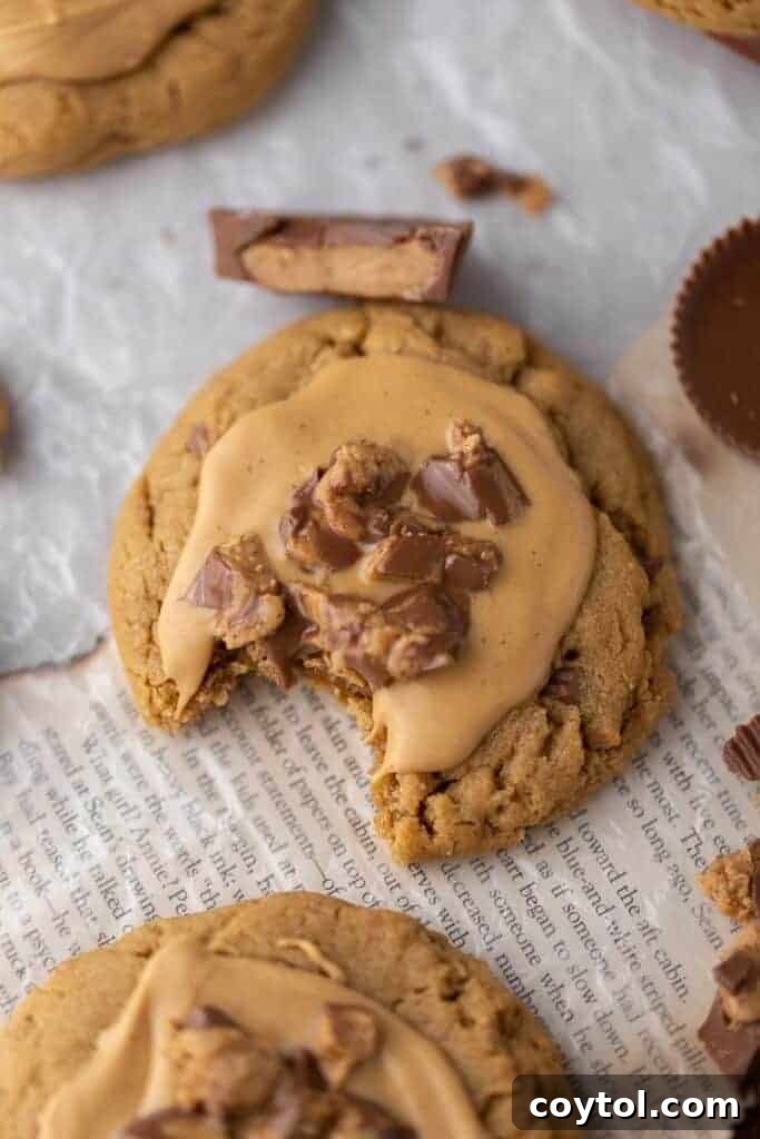 Overhead shot of Crumbl peanut butter cookies on a serving tray with extra Reese's cups.