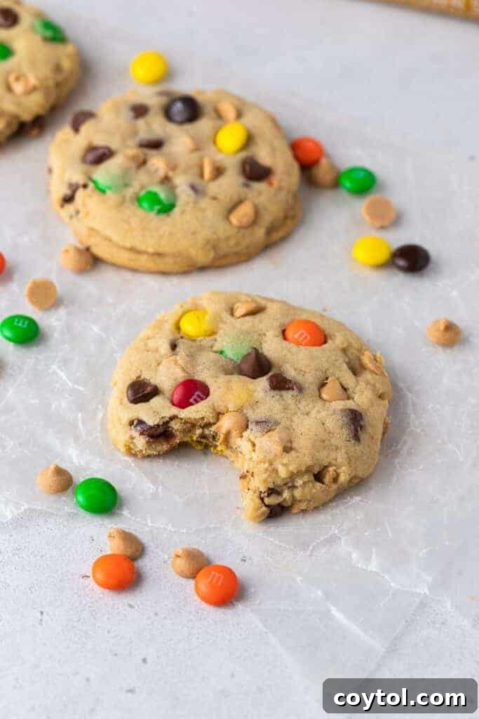 A large Crumbl monster cookie with a bite taken out, revealing its thick, chewy interior and abundant mix-ins.