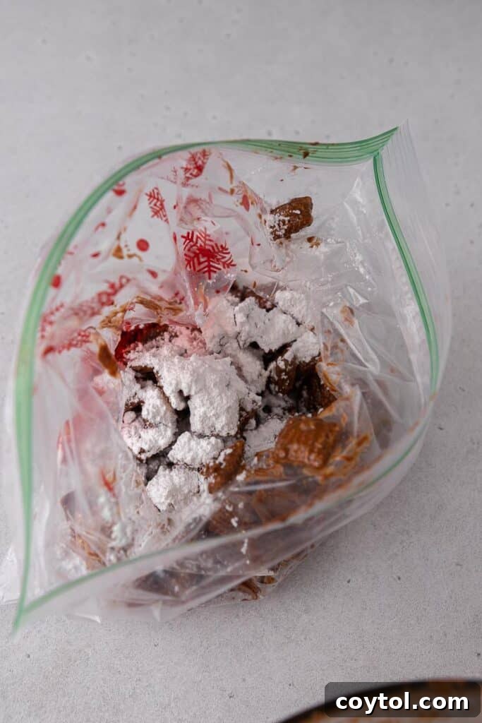 Muddy buddies being shaken in a bag with powdered sugar to fully coat the cereal