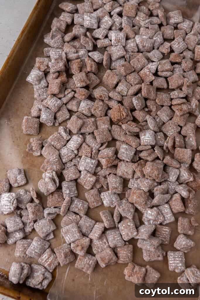 Powdered sugar-coated cereal spread on a baking sheet to cool and dry