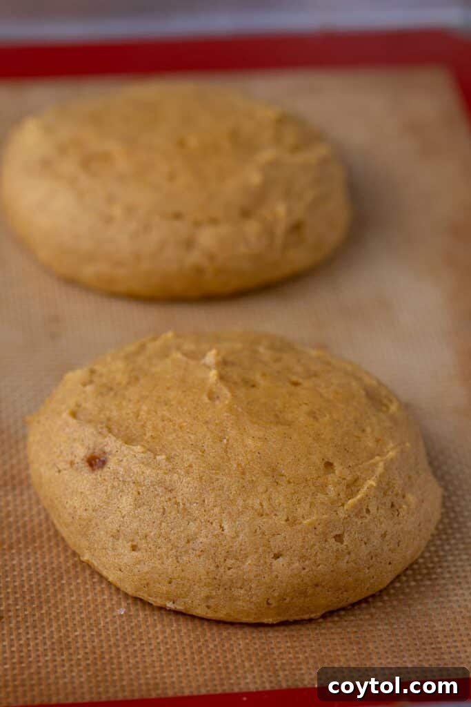 Scooped pumpkin cookie batter on a baking sheet