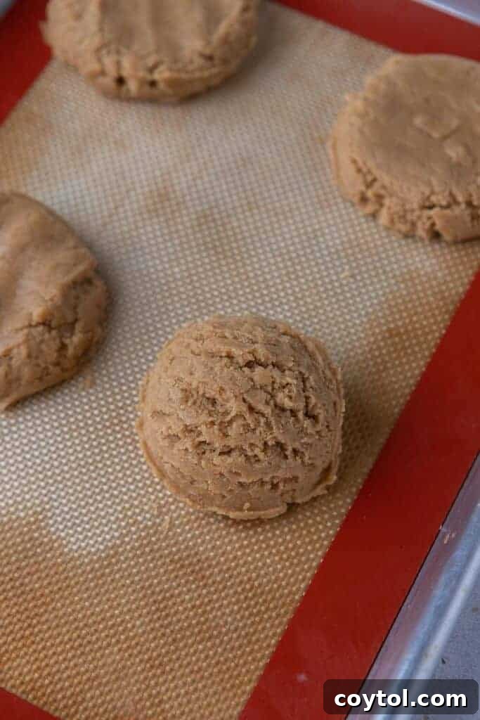 Peanut butter cookie dough rolled into balls on a baking sheet