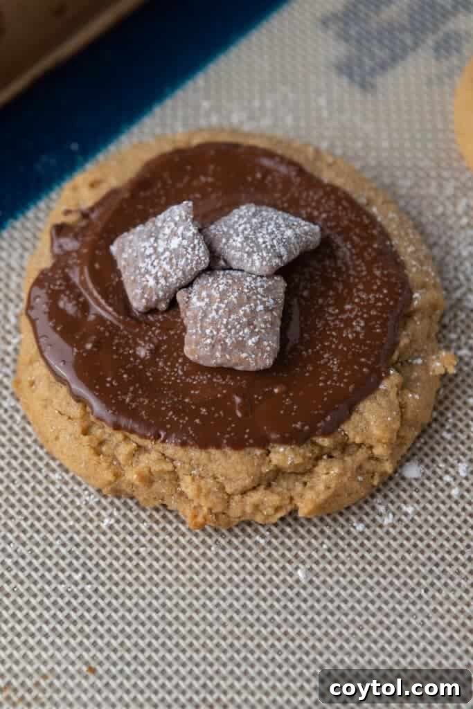 Baked Crumbl muddy buddy cookies with melted chocolate and Chex pieces