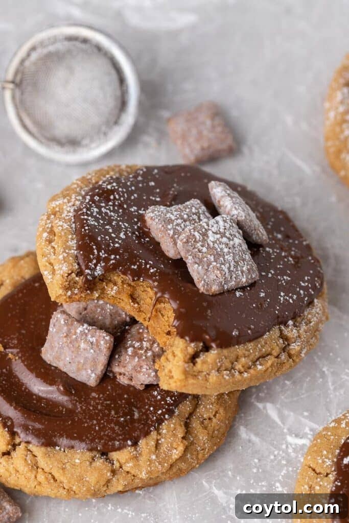 A Crumbl Muddy Buddies cookie garnished with extra muddy buddies pieces