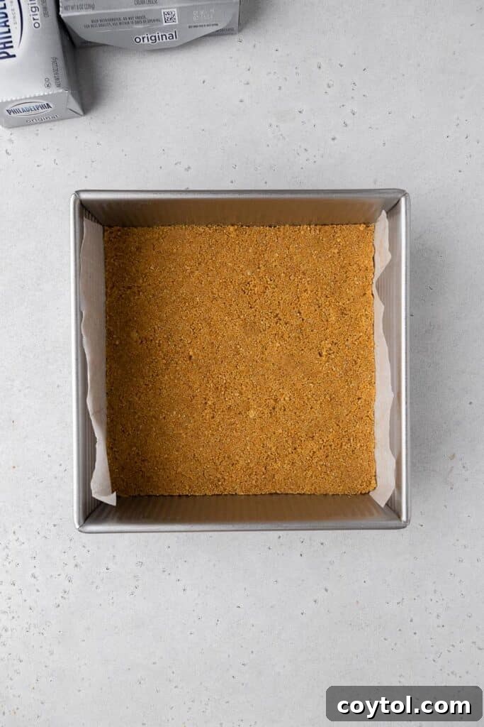 Baked graham cracker crust perfectly pressed into an 8x8-inch baking pan.