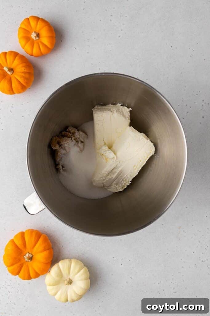 Creaming softened cream cheese with granulated and brown sugars.