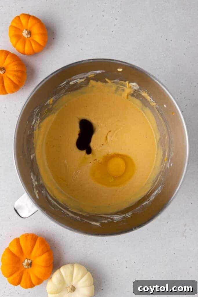 Smooth pumpkin cheesecake batter in a mixing bowl, ready for baking.