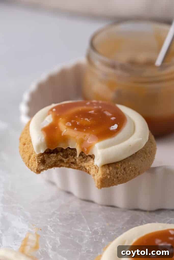 Crumlb salted caramel cheesecake cookie with a bite taken out of it