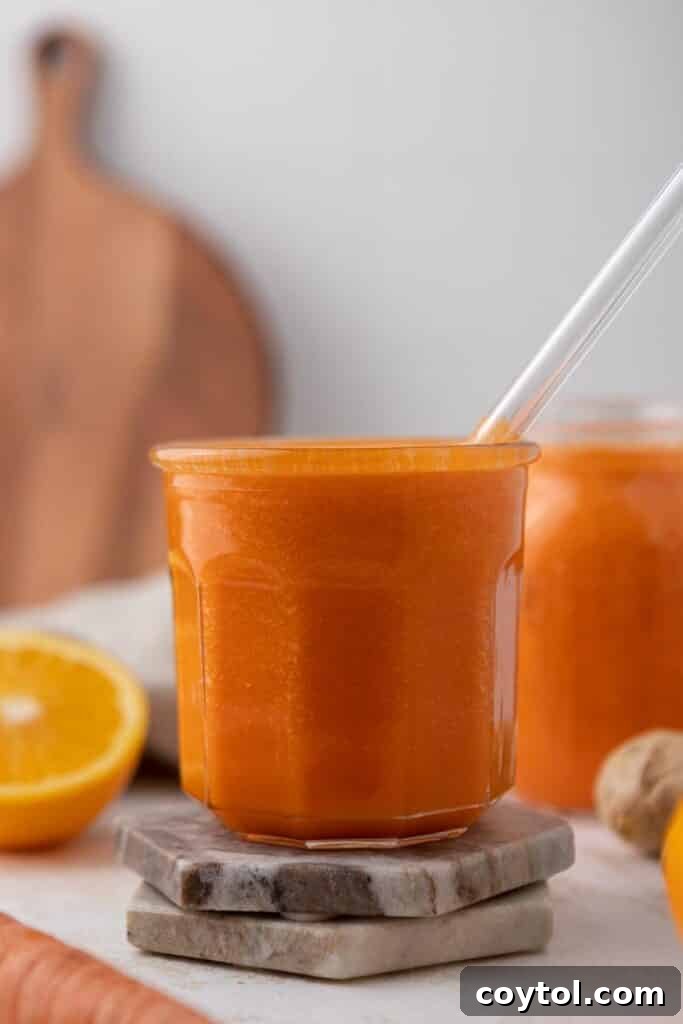 Golden Glow Immune Support Smoothie 5 A bright orange smoothie poured into a clear glass, ready to be enjoyed, showcasing its smooth texture.