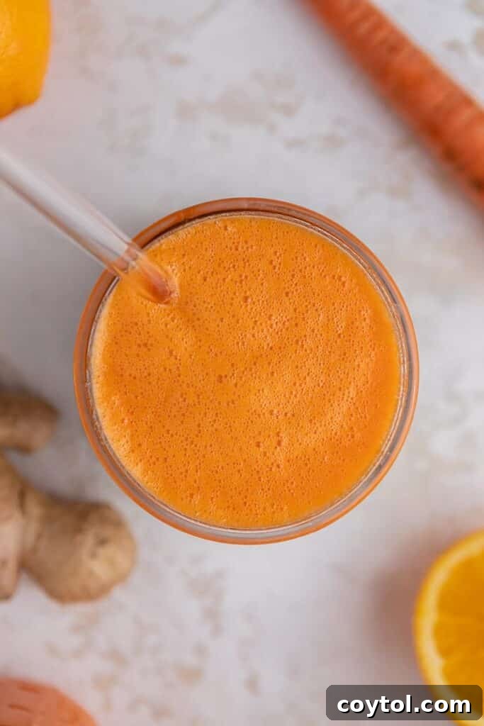 Golden Glow Immune Support Smoothie 6 An overhead shot of a ginger carrot orange smoothie in a tall glass, set against a rustic background, highlighting its rich color.