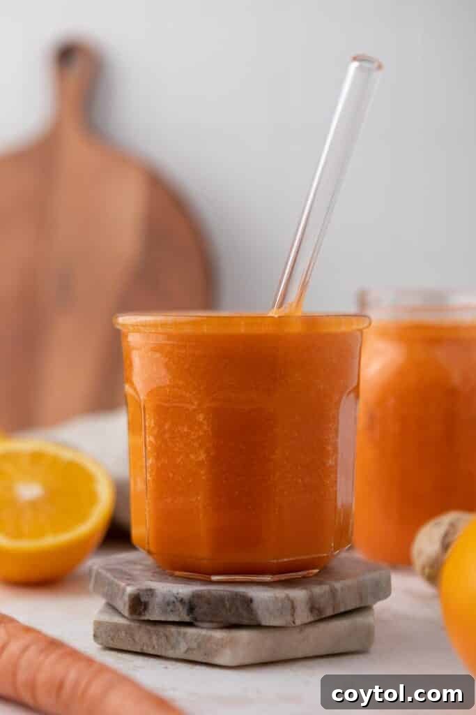 Golden Glow Immune Support Smoothie 7 A refreshing ginger carrot orange smoothie in a glass, symbolizing its detoxifying and debloating benefits.