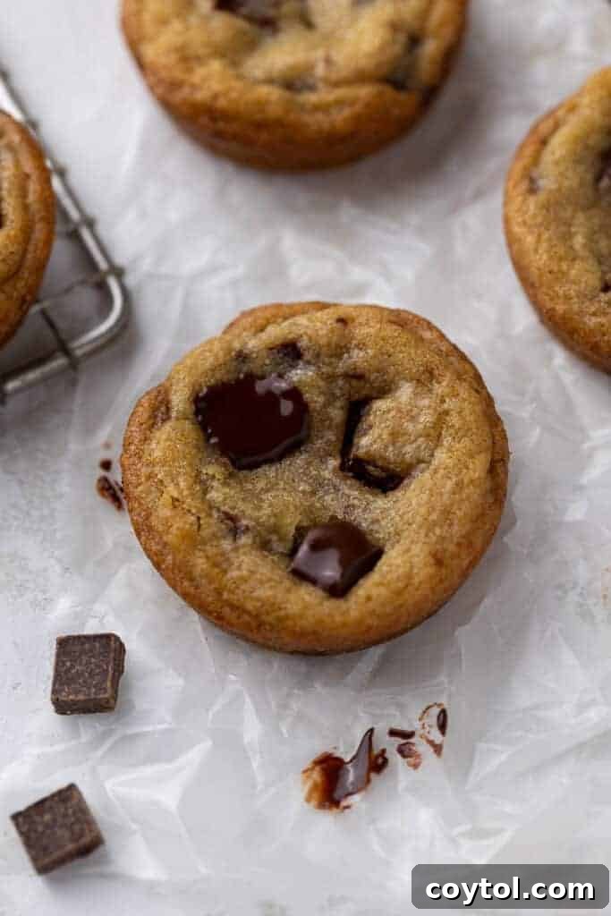 Delightful Mini Crumbl Chocolate Chip Cookie Cups 11 A small stack of perfectly baked mini chocolate chip cookies, still warm and inviting, ideal for quick treats or for a dessert spread.