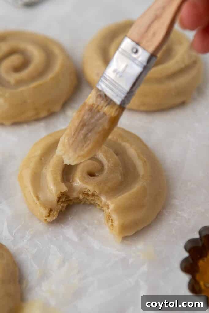 Crumbl Honey Bun Cookies: Sweet Perfection 12 A pastry brush applying honey butter glaze to a warm cookie.