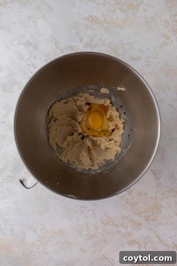 Crumbl Honey Bun Cookies: Sweet Perfection 5 Creamed egg, sugar and butter in mixing bowl, forming the cookie base.