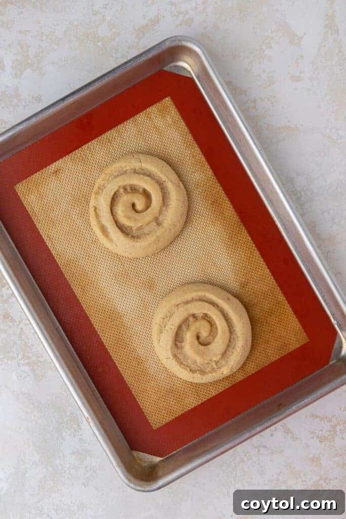 Crumbl Honey Bun Cookies: Sweet Perfection 8 Baked honey bun cookies on baking sheet, fresh out of the oven.