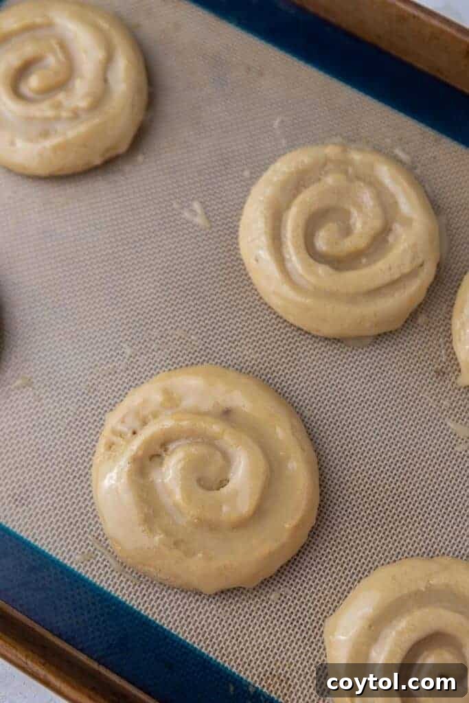 Crumbl Honey Bun Cookies: Sweet Perfection 9 Glazed honey bun cookies cooling on a wire rack.