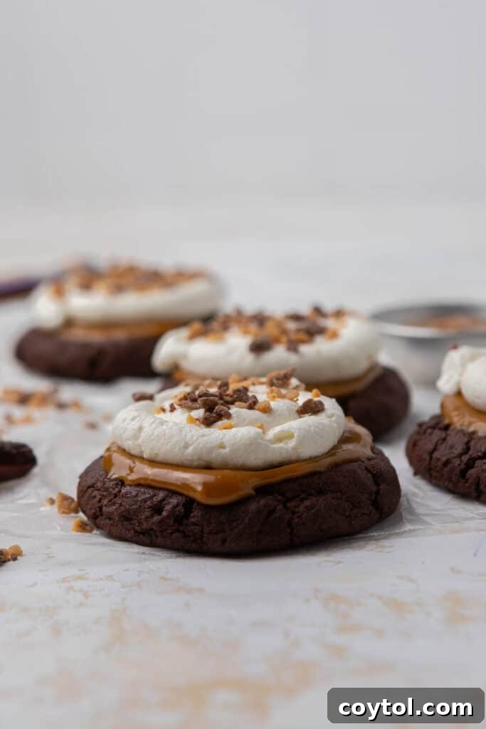 Irresistible Chilled Crumbl Heath Cake Cookies 3 Straight on shot of chocolate caramel cookies with whipped cream on top