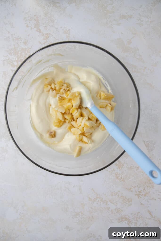 Crumbl's Sublime Chilled Banana Cream Pie Cookies 5 Step-by-step image of whisking milk and pudding mix for banana cream pie filling.