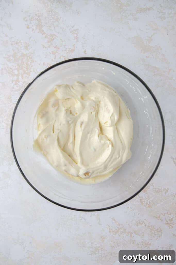 Crumbl's Sublime Chilled Banana Cream Pie Cookies 6 Step-by-step image of folding cool whip into the banana cream pie filling mixture.