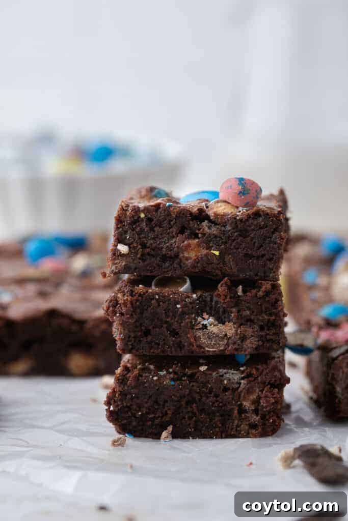 Stack of fudgy egg candy brownies, showcasing their rich texture