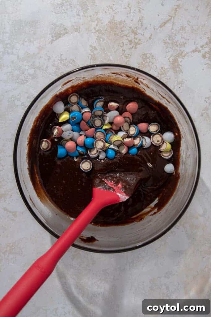 Easter brownie batter in a bowl with mini eggs folded in