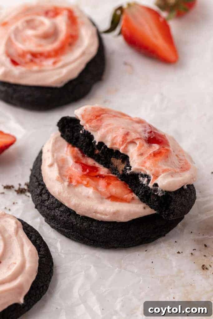 Chilled Strawberry Cheesecake Swirl Chocolate Cookies 2 Decadent Crumbl Chocolate Strawberry Cheesecake Cookies with rich dark base and pink frosting, garnished with fresh strawberry slices.