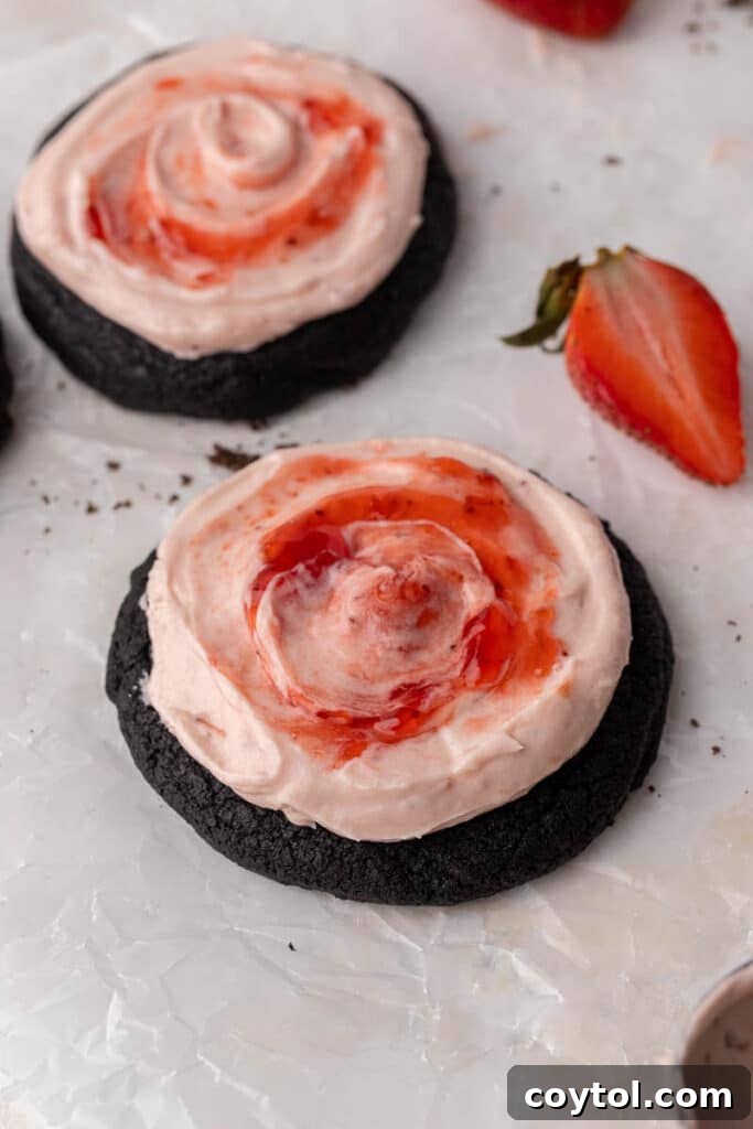 Chilled Strawberry Cheesecake Swirl Chocolate Cookies 11 A tray of beautifully frosted Crumbl Chocolate Strawberry Cheesecake Cookies, glistening with strawberry jam swirls.