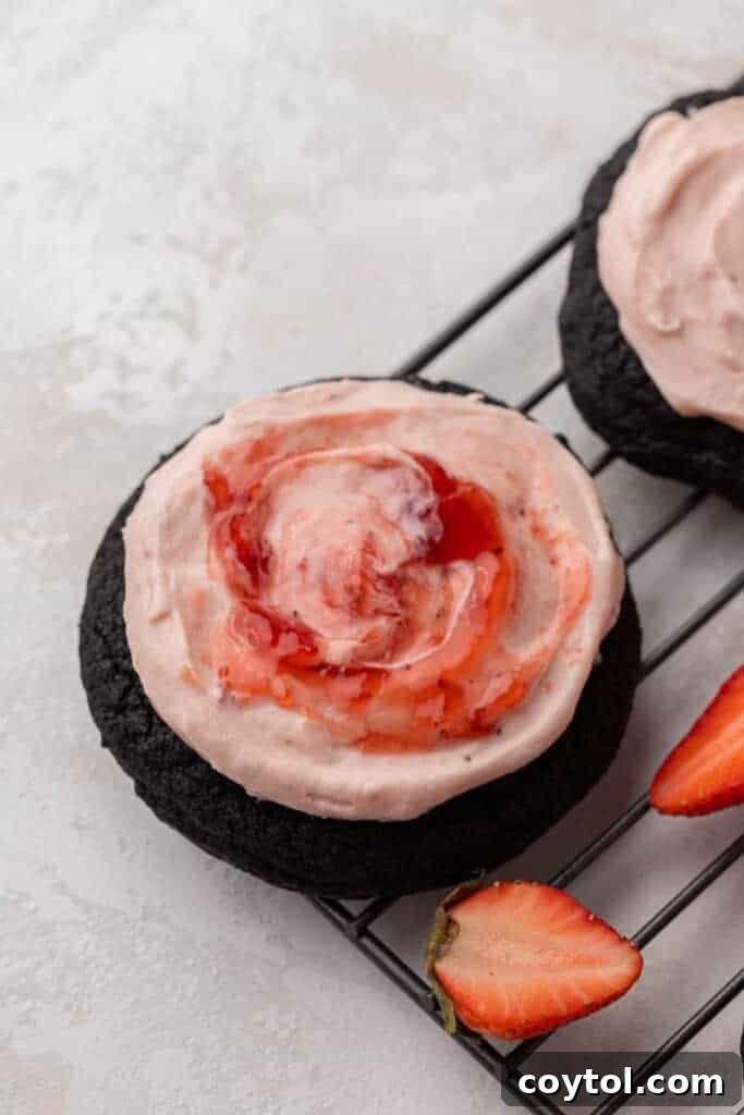 Chilled Strawberry Cheesecake Swirl Chocolate Cookies 10 Strawberry jam being swirled into the pink cream cheese frosting on a cookie.