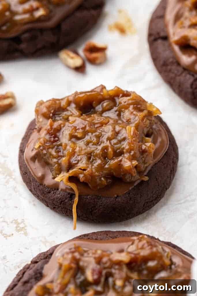 Crumbl German Chocolate Cake Cookies - A close-up shot of a thick, frosted chocolate cookie with chocolate drizzle and coconut pecan topping.