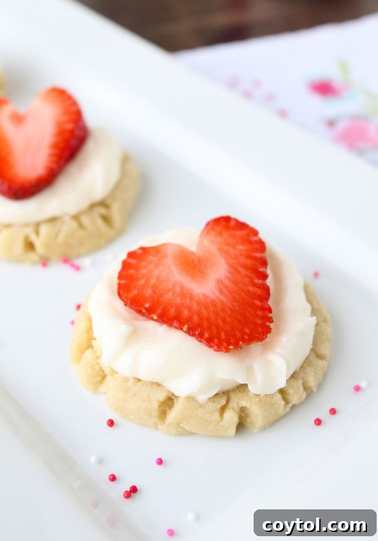 18 Irresistible Valentine's Day Cookie Ideas 17 Soft sugar cookies with creamy coconut frosting, decorated with fresh strawberry hearts for Valentine's Day.