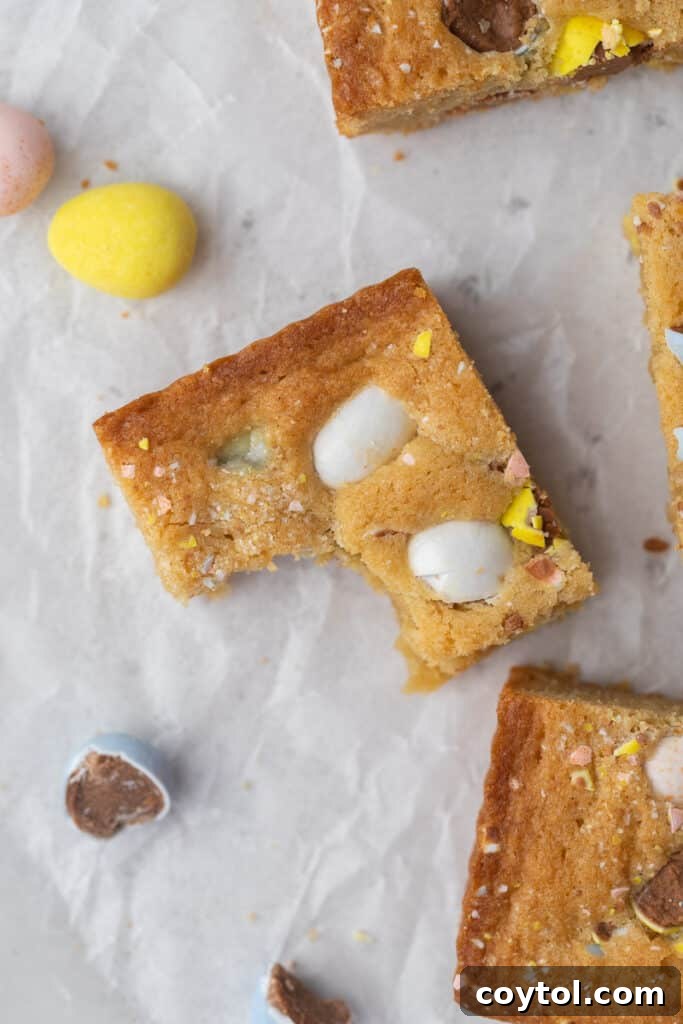 A perfect slice of Cadbury Mini Egg Blondie revealing the chewy interior and colorful chocolate pieces