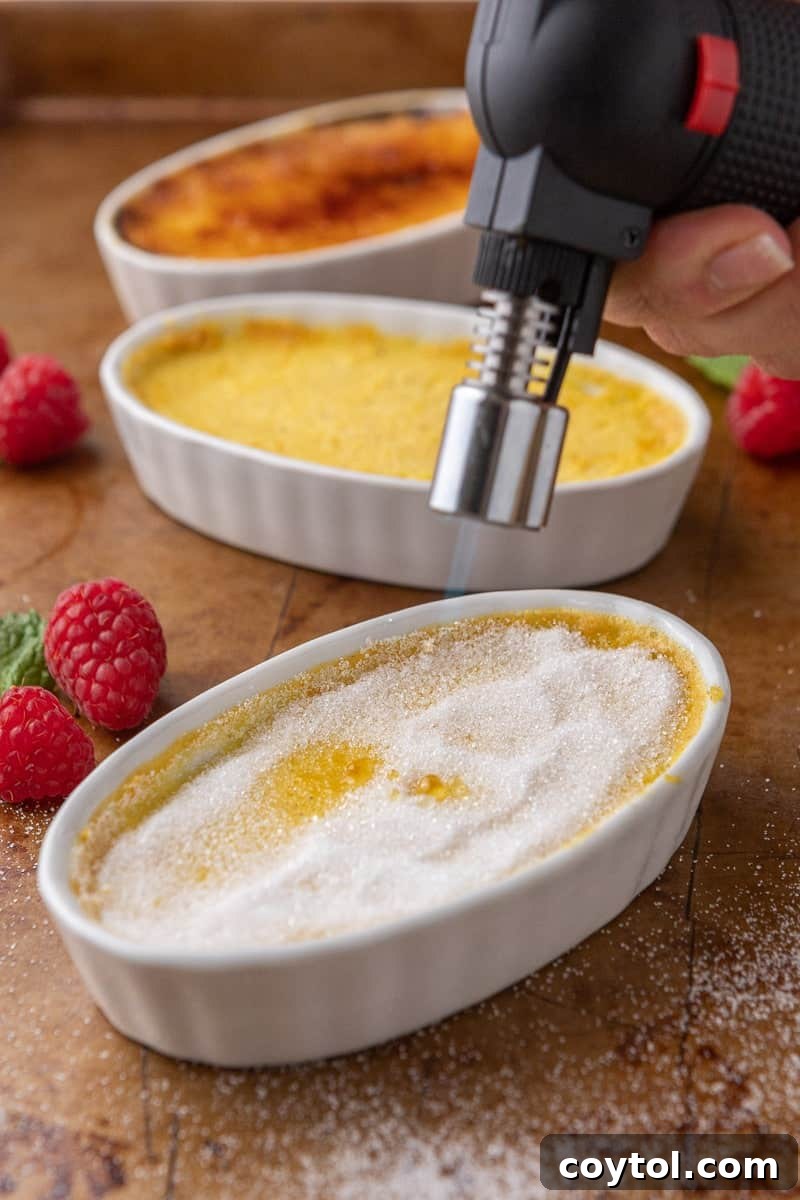 Effortless Indulgence: 3-Ingredient Creme Brulee & Ice Cream 9 Kitchen torch caramelizing granulated sugar on top of a creme brulee, creating the crunchy crust