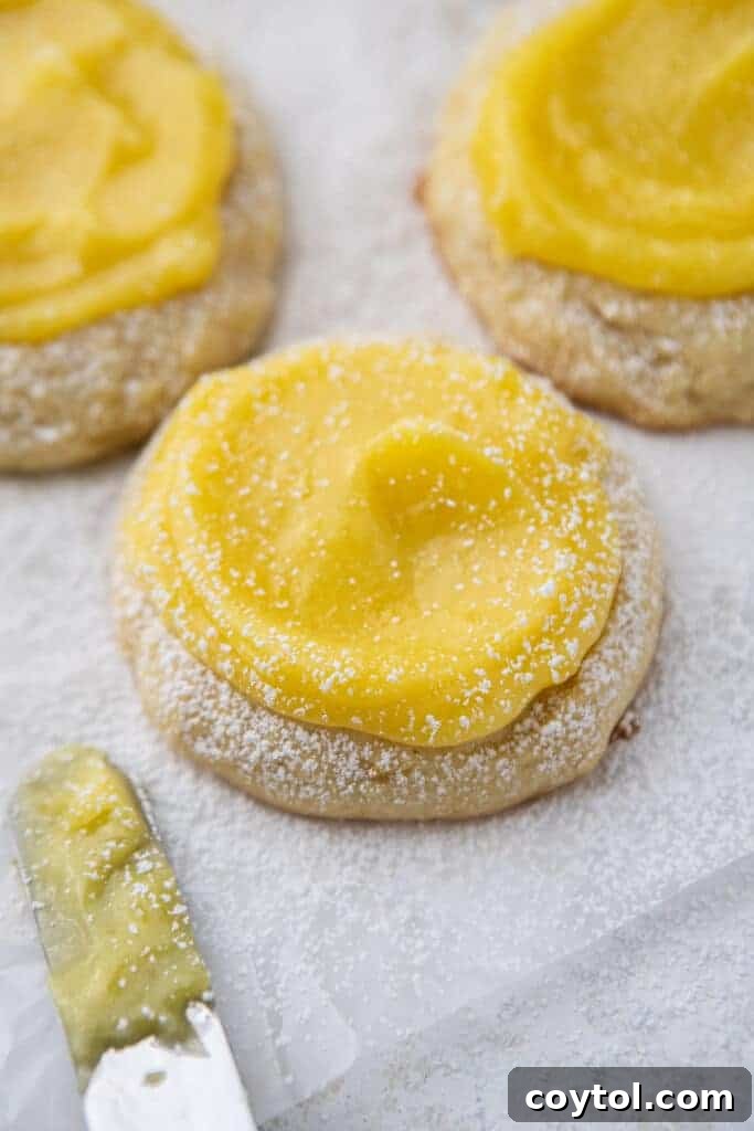 Zesty Chilled Lemon Bar Cookies 2 Crumbl lemon bar cookies, close up of a cookie with lemon curd
